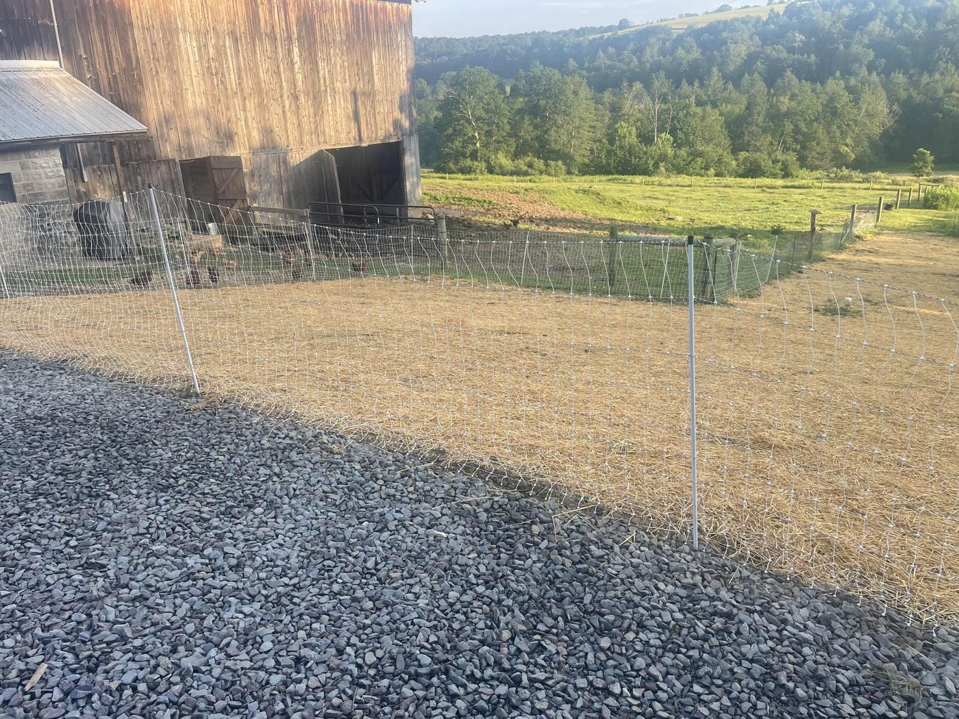 Stone laid down along the pasture fence by the barn.