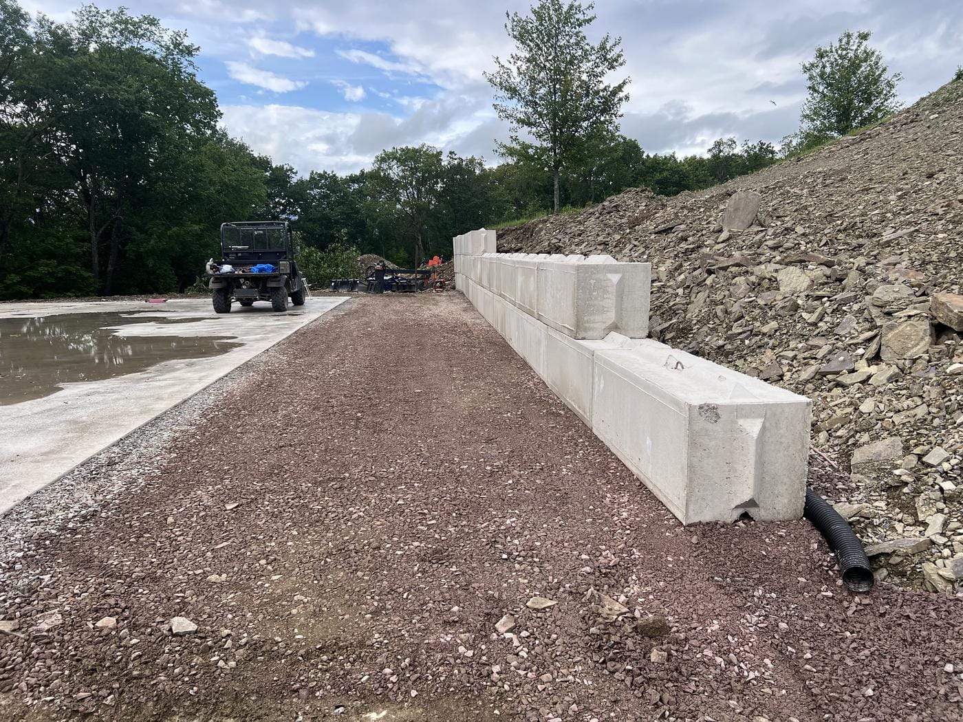 Concrete block set along a new gravel lane beside the slab.