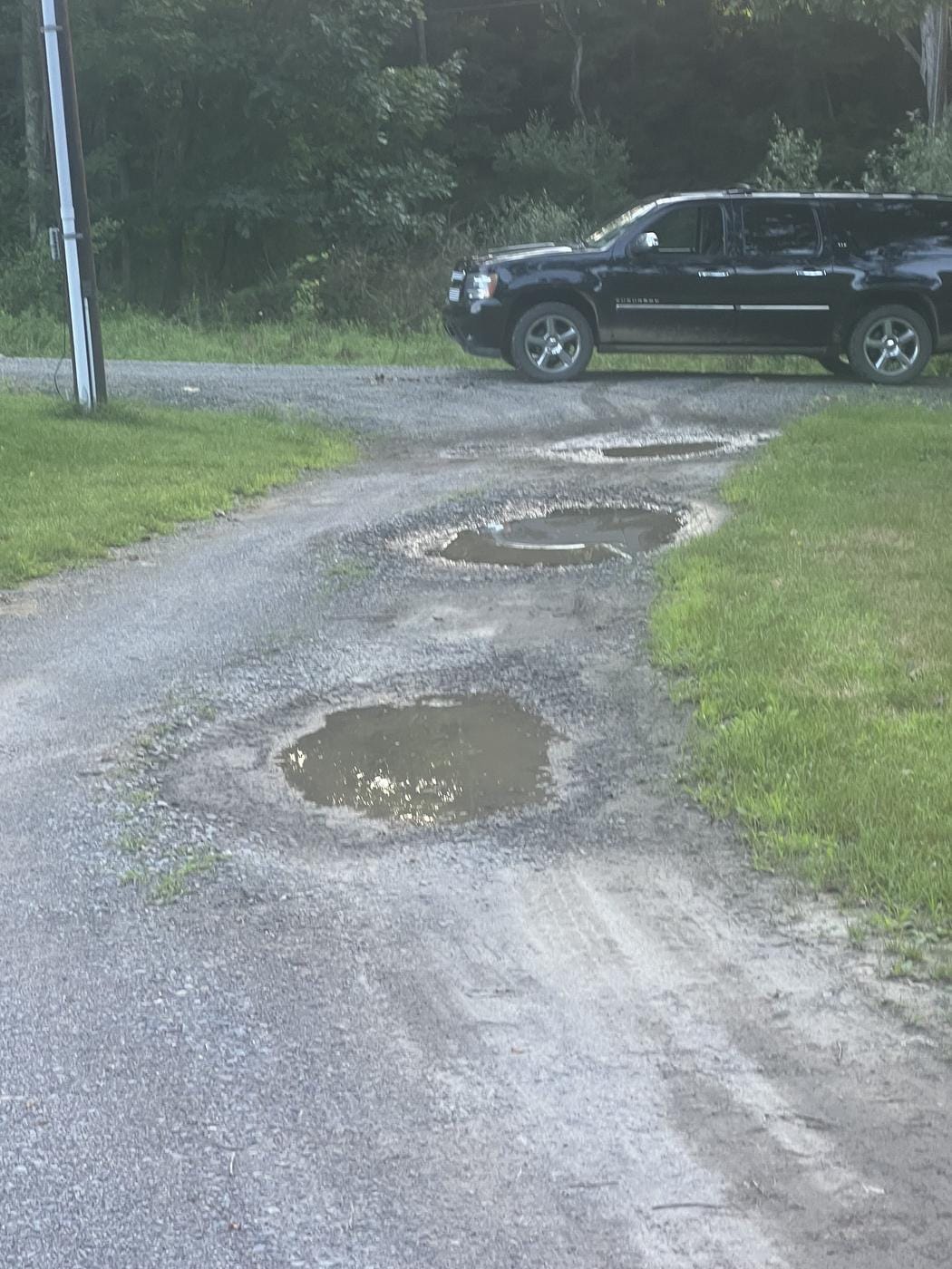 An old gravel drive full of potholes.