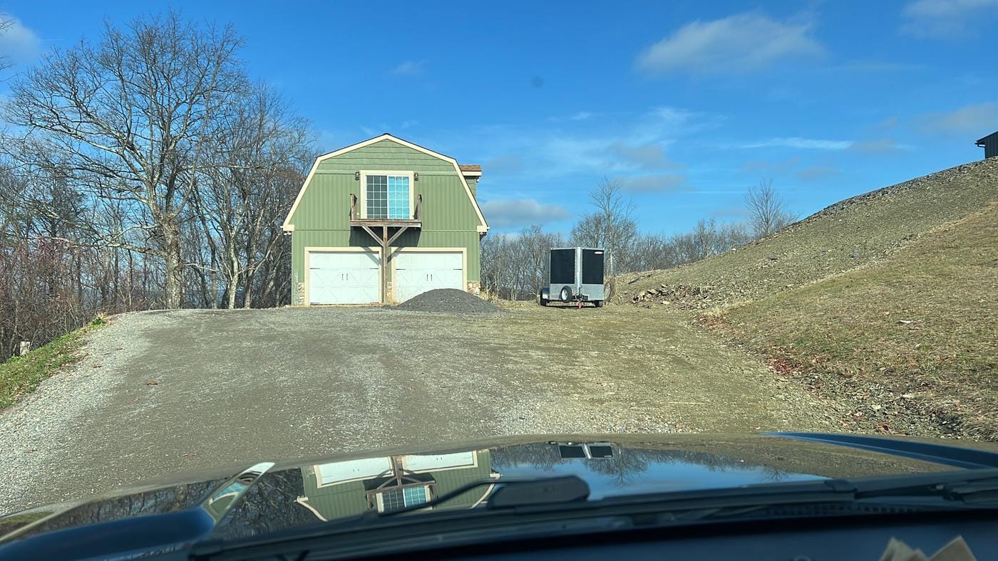 A gravel drive up to a two-bay garage.